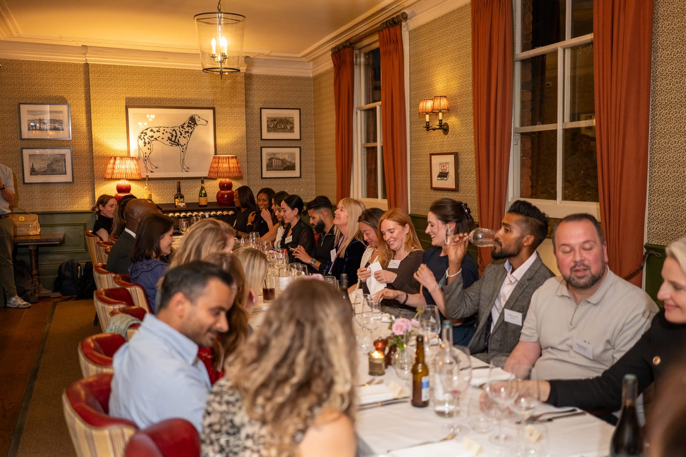 Clinic owners laughing around the dinner table at the Clinic Circle event